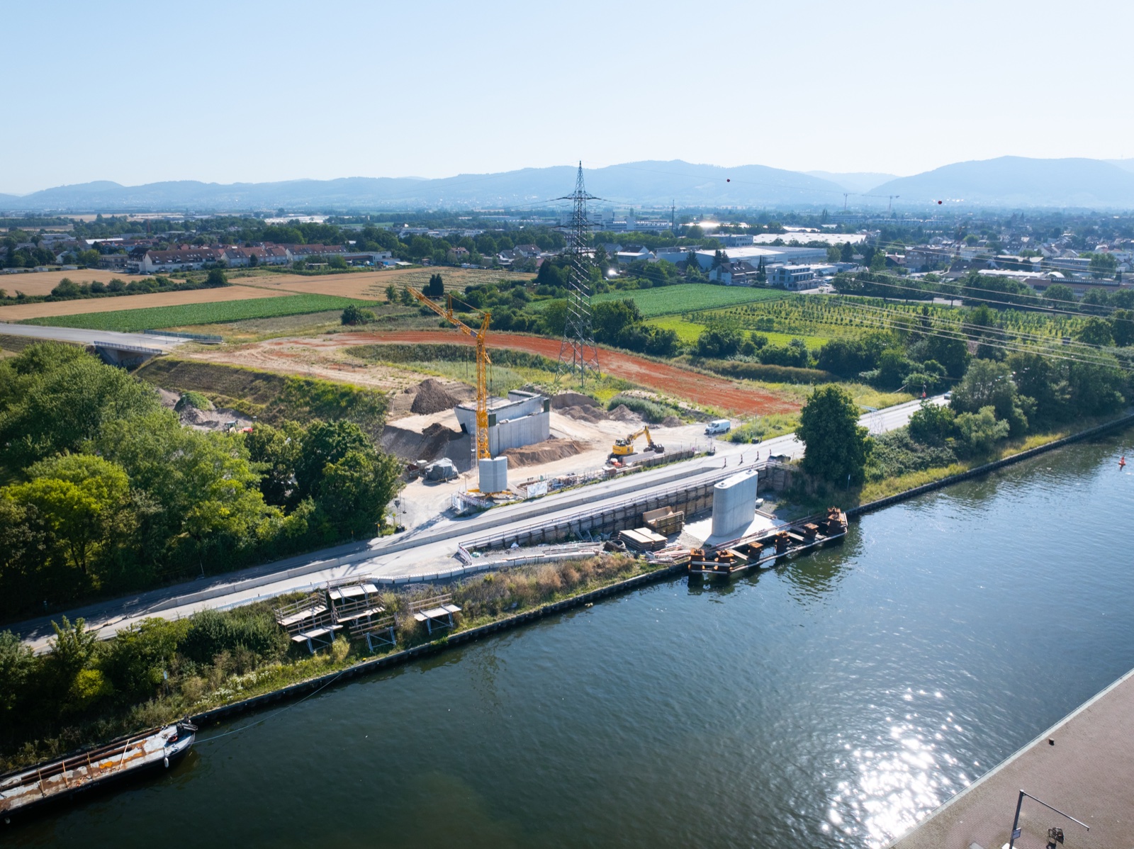 Luftaufnahme der Brückenbaustelle am Neckarufer in Ladenburg.
